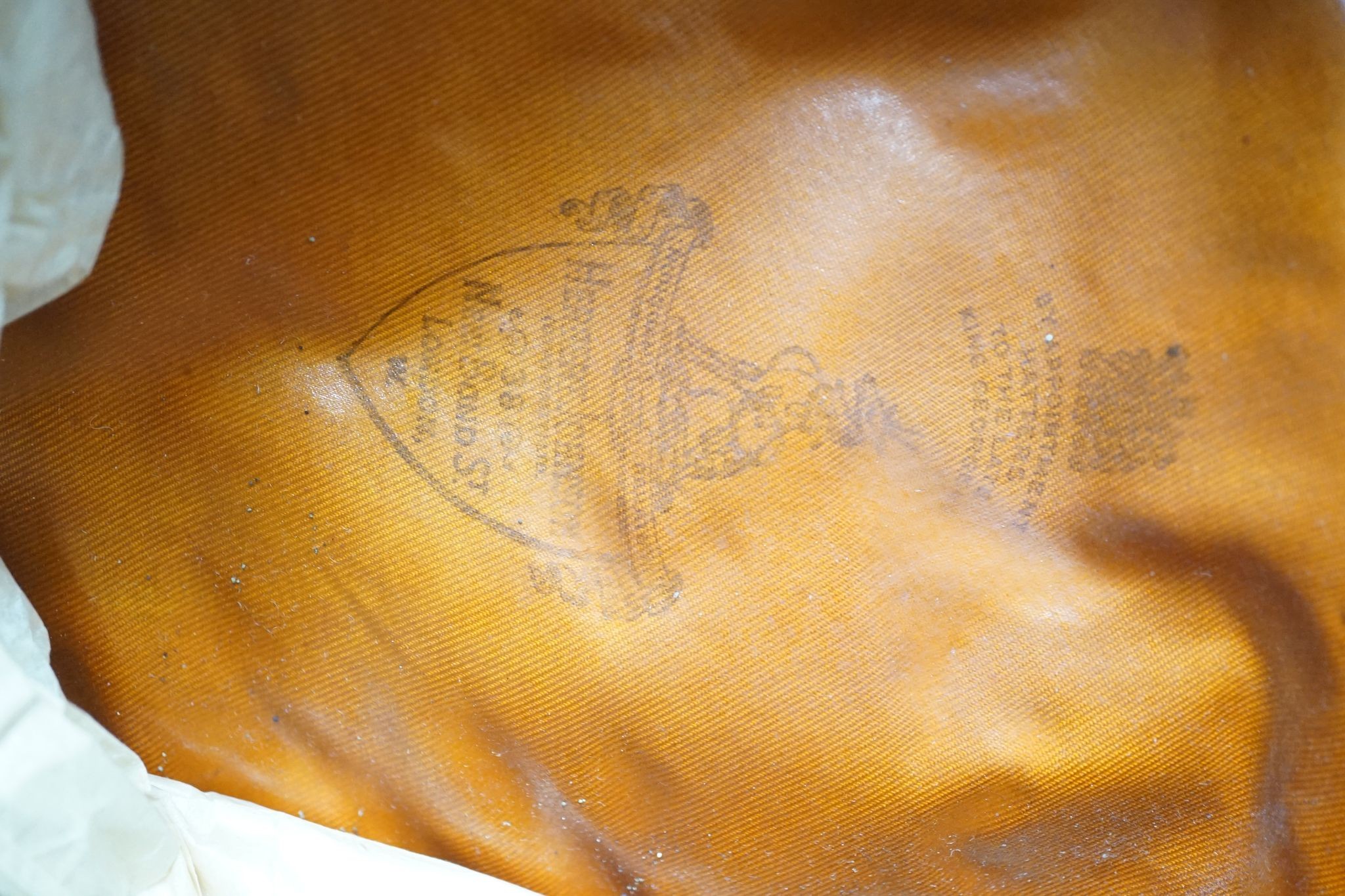 Two army officers' caps in brown leather hat box.